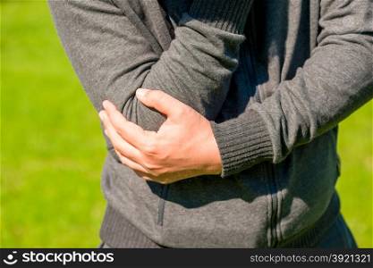 man holding his elbow arthritic closeup
