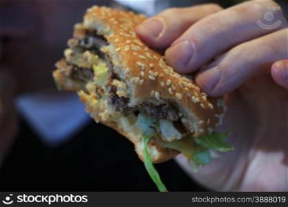 Man holding his hamburger, close up of hamburger
