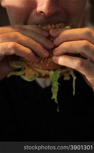 Man holding his hamburger, close up of hamburger
