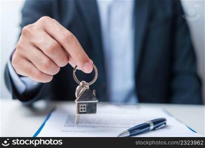 man holding home key during signing home contract documents. Contract agreement, real estate,  buy and sale and insurance concepts