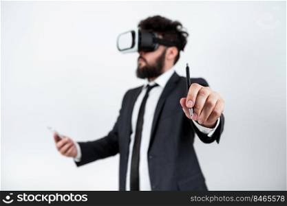 Man Holding Mobile Phone, Wearing Vr Glasses And Pointing On New Idea.. Man Holding Mobile Phone, Wearing Vr Glasses And Pointing On Recent Updates With Pen. Businessman Having Virtual Reality Eyeglasses, Cellphone And Presenting New Idea.