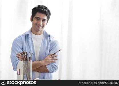 Man holding paintbrush in art studio