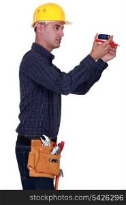 Man holding pencil and tape measure