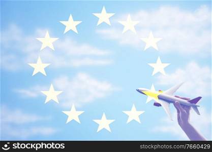 Man holding plane toy against european flag