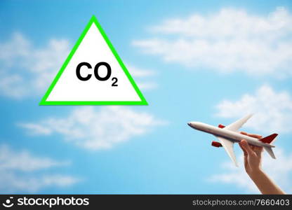 Man holding plane toy with carbon dioxide sign 