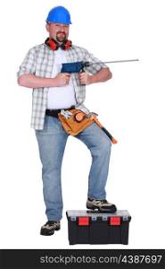 Man holding power drill and resting foot on tool box