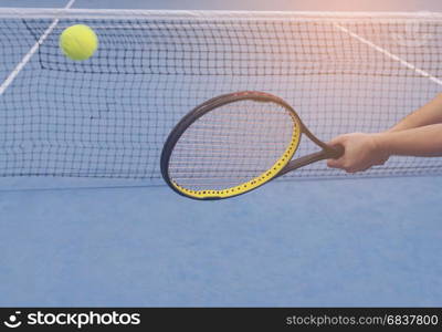 Man holding racket about to hit a ball in tennis court