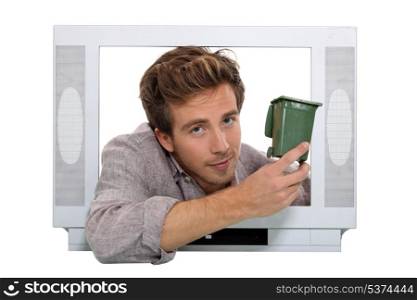 Man holding recycling bin inside television