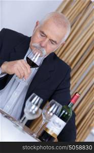 man holding red wine in glass