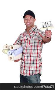 Man holding rolls of wallpaper