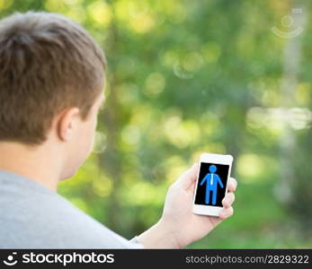 Man holding smartphone in hand outdoors. Communication concept