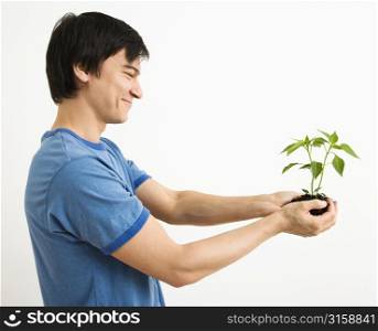 Man holding soil and a plant