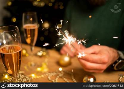 man holding sparkles and champagne glass New Year party