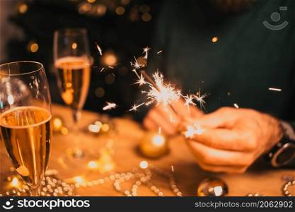 man holding sparkles and champagne glass New Year party