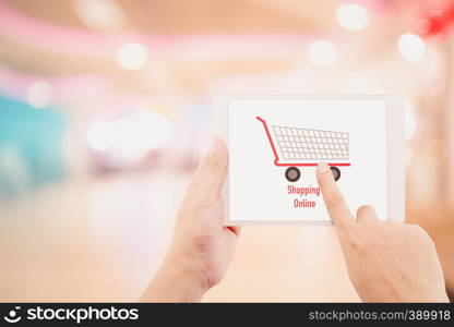 Man holding tablet, over blur or defocus image of department store or with bokeh background, shopping online concept.