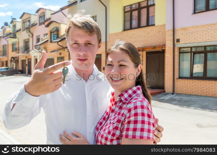 man holding the key to the house and embracing his wife