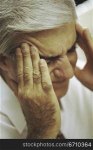 Man holding the side of his head in pain