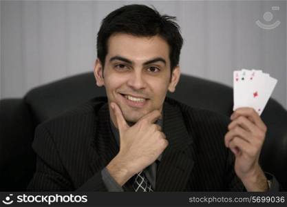 Man holding three aces