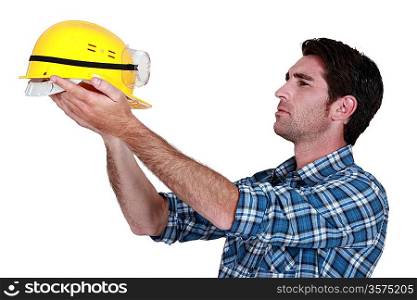 Man holding up a construction helmet