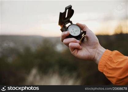 man holding up compass while road trip