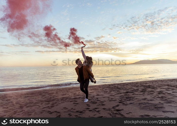 man holding woman with smoke bomb back