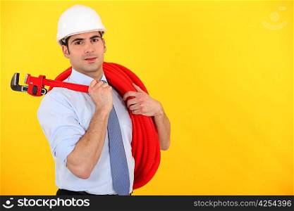 Man holding wrench and coiled pipe