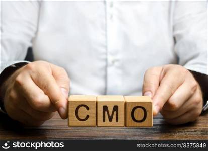 Man holds abbreviation CMO. Marketing strategy of the company. Post top manager Chief Marketing Officer. PR and advertising, establishing public relations and the media