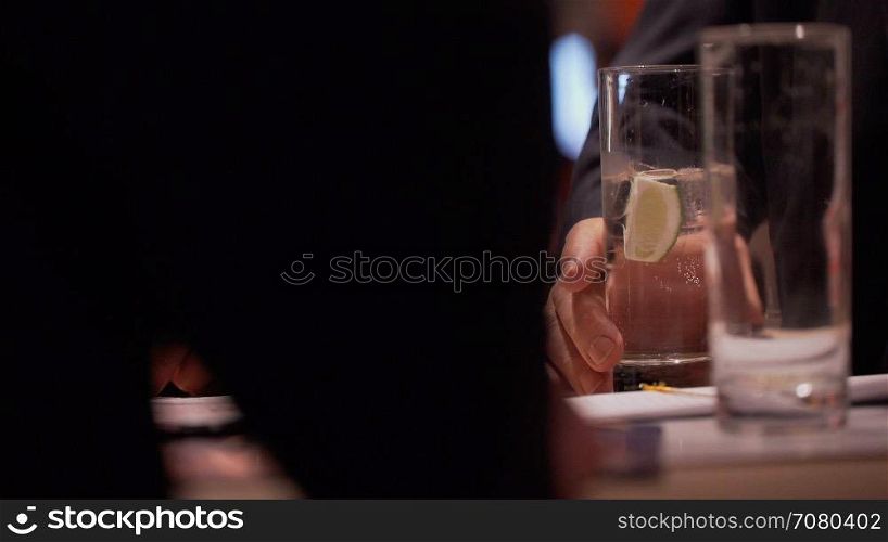 Man holds drink at a conference