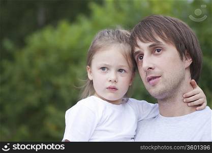 Man holds girl with her hand round his neck