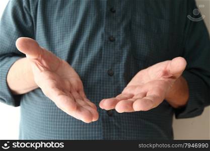 Man holds his hands out in a gesture with several meanings.