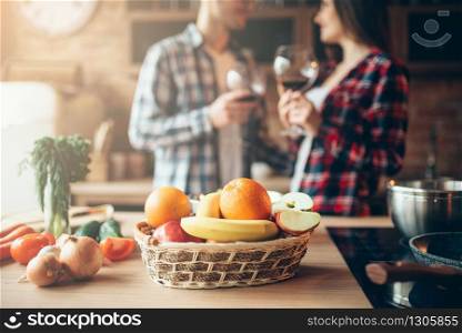 Man holds piece of fresh raw meat, kitchen interior on background. Chef cooking tenderloin with vegetables, spices and herbs. Man holds piece of fresh raw meat