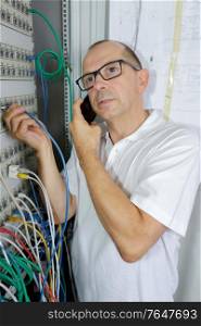 man holds server cable in server rack