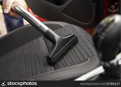 Man Hoovering Seat Of Car During Car Cleaning