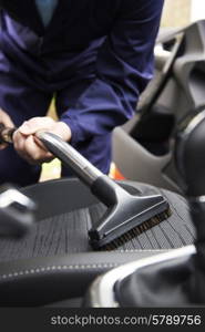 Man Hoovering Seat Of Car During Car Cleaning