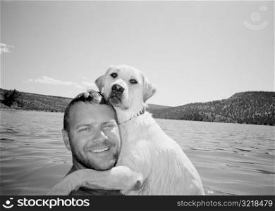Man Hugging Dog In Mountain Lake
