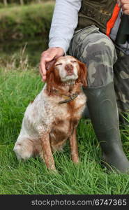 man hunting and caressing his dog