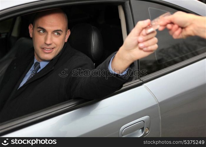 Man in a car using a credit card
