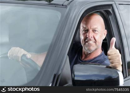 man in a car with thumbs up