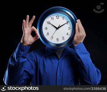 man in a dark blue shirt holds hours in the face of
