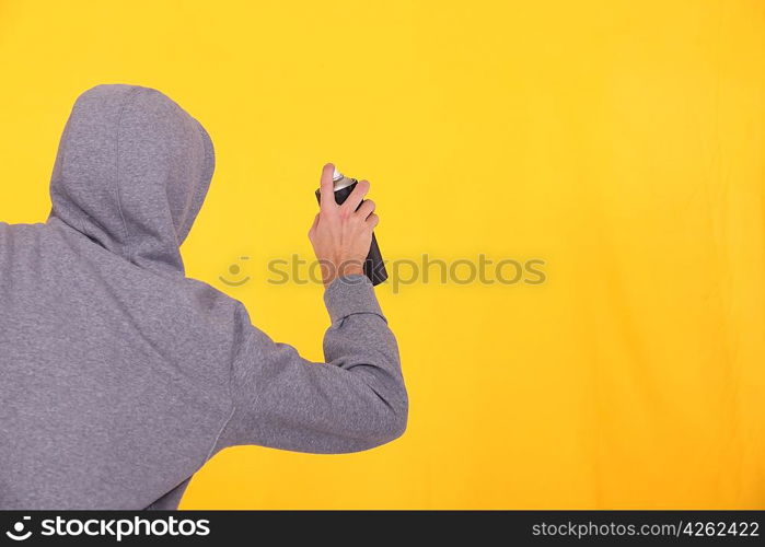 Man in a hoodie spray painting