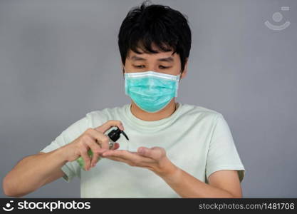 man in a medical mask(surgical mask) using alcohol gel, coronavirus protection