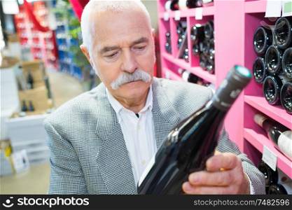 man in a supermarket buying wine