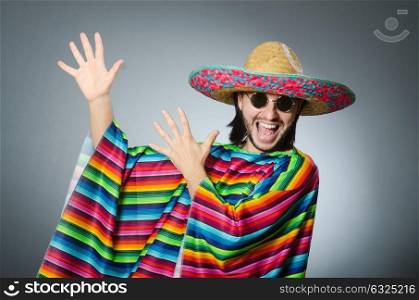 Man in a vivid mexican poncho gray background isolated