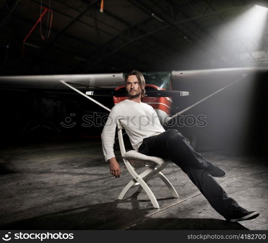 Man in a warehouse with an airplane.