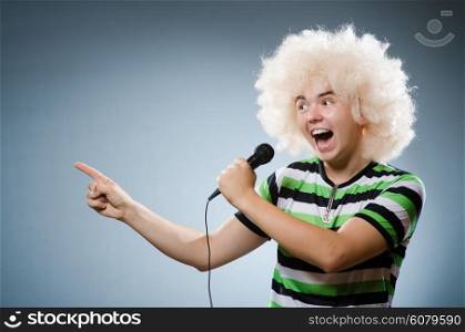 Man in afrowig singing with mic