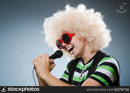 Man in afrowig singing with mic