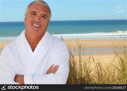 Man in bathrobe on beach
