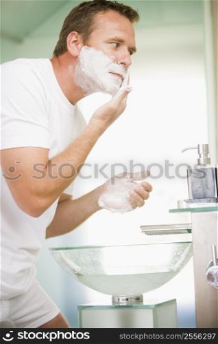 Man in bathroom shaving