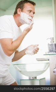 Man in bathroom shaving