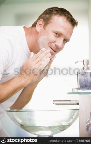 Man in bathroom washing face